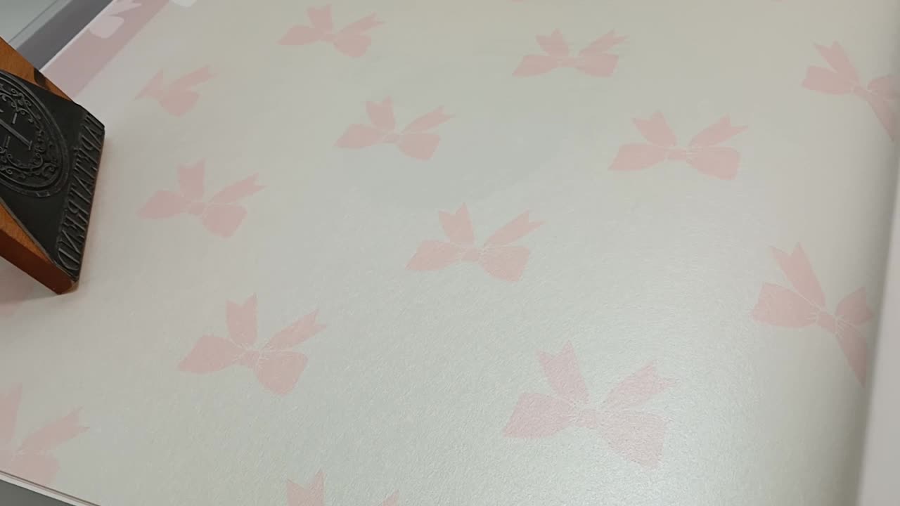 Gyerek design tapéta gyöngyház alapon rózsaszín masni mintával