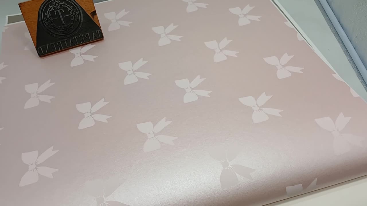 Gyerek design tapéta púder rózsaszín alapon rózsaszín masni mintával